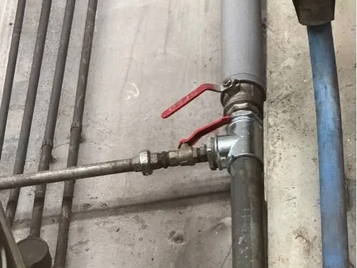Główny zawór odcinający z czerwoną rączką — DobryHydraulik Kraków